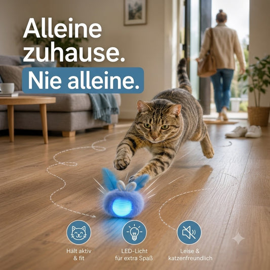 Eine grau getigerte Wohnungskatze jagt voller Begeisterung einem leuchtend blauen, selbstfahrenden Spielball mit Hasenohren durch das Wohnzimmer. Im Hintergrund verlässt der Besitzer gerade die Wohnung, während die Katze konzentriert hinter dem interaktiven Spielzeug herspringt. Die gestrichelte Bewegungsbahn auf dem Holzboden vermittelt Dynamik und zeigt, wie der Ball zufällig seine Richtung wechselt. Großes Text-Overlay: „Alleine zuhause. Nie alleine.“ Die Szene vermittelt selbstständige Beschäftigung, Be